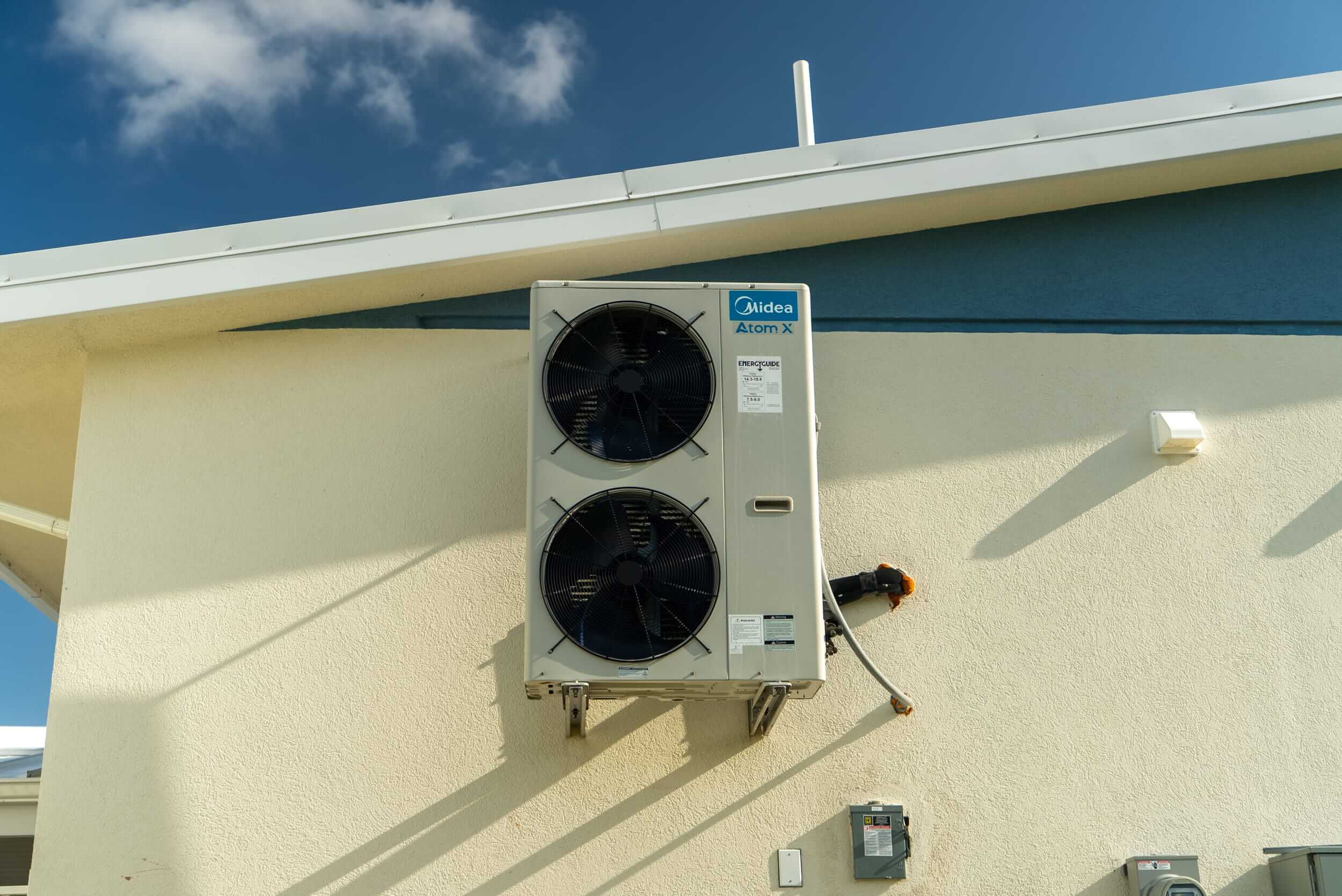 Midea Atom X outdoor air conditioning unit mounted on an exterior wall